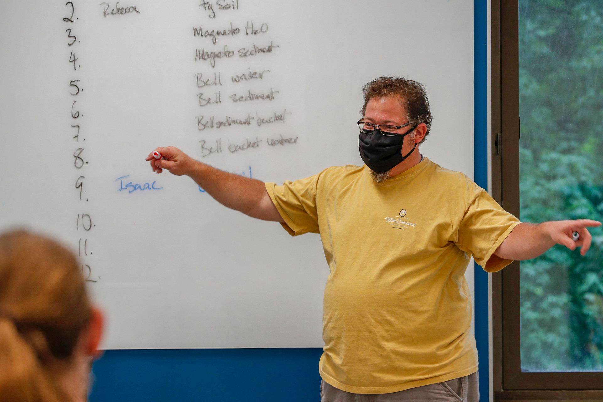 An instructor teaches while wearing a face mask